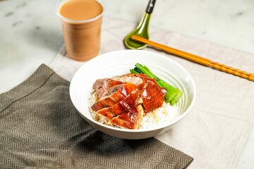 Roasted Goose with Rice with milk kopi chopsticks and spoon served in bowl isolated on napkin side...