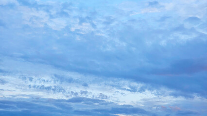 A serene blue sky filled with soft, wispy clouds, creating a peaceful