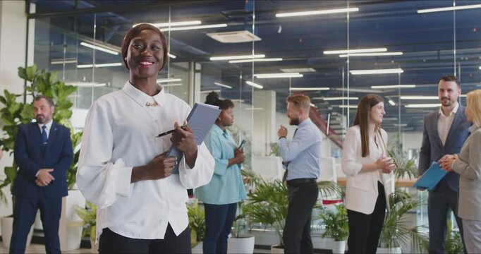 Portrait of a happy African American businesswoman during an office meeting. She is a professional manager or executive, exuding positivity and business acumen in the professional setting.
