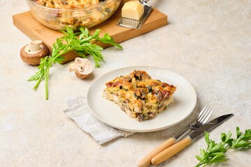 Sliced ​​zucchini casserole with mushrooms, chicken and cheese on a plate on a light concrete background. Zucchini recipes, casseroles.