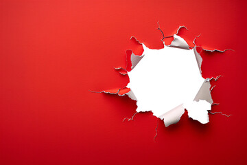ripped transparent hole in red paper, torn hole