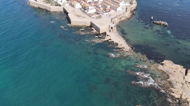 Tabarca, Spain from the air. Bright sunny day, azure water, yachts anchored in the bay. Tranquil sea, vibrant city, and beach crowded with tourists. Costa Brava attraction.