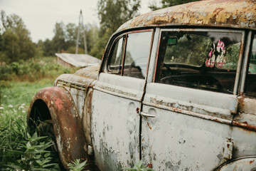 Rusty abandoned vintage car in a field
