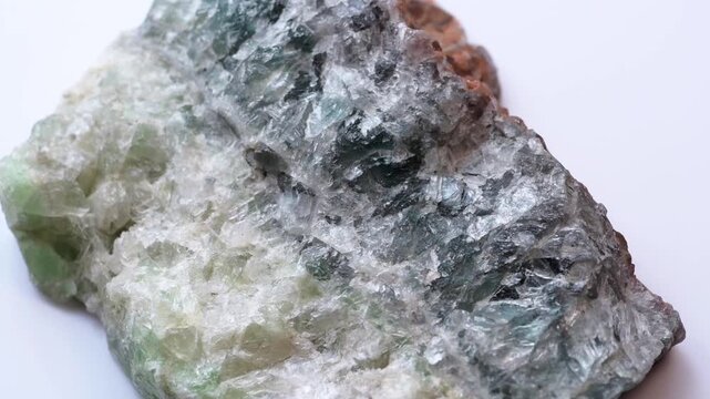 A sample of fluorite on a white background. Chlorophane fluorite is a mineral. Fluorite druse spinning 3d on a white background.