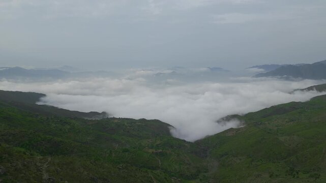 Aerial view of majestic mountains rising above the clouds in Buner, Pakistan