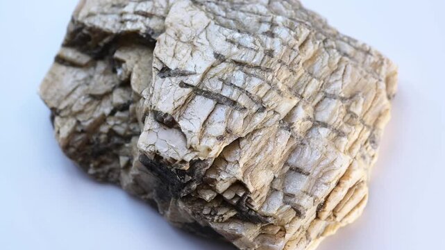 A sample of written granite. The granite-pegmatite mineral rotates in 3d on a white background. Raw rock.