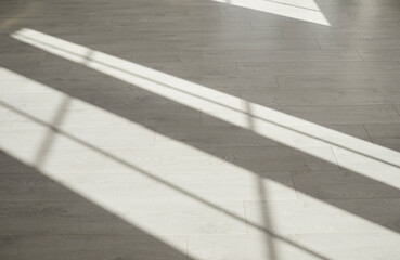 Sunlight on floor at home. Bright light from windows on clean grey parquet, laminate, vinyl or wood imitation linoleum in empty modern building. Indoor shot, no people, nobody, concept background