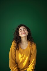 Obraz premium Happy young woman in casual outfit smiling while standing against green background