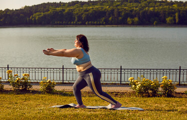 Overweight fat young woman wearing sportswear doing sport fit exercises in the summer city park....