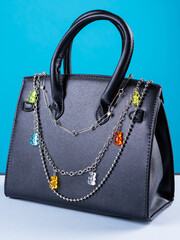 Close up of metal chain with bears on fashionable black bag