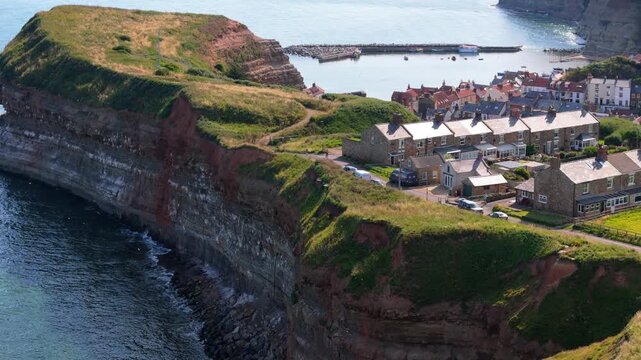 Aerial drone view of Staithes Harbour on the North Yorkshire coast with river,houses, boats on a sunny morning in August, summertime