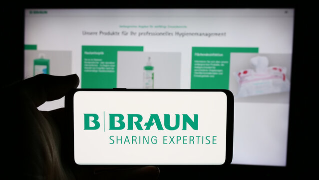 Stuttgart, Germany - 07-31-2024: Person holding cellphone with logo of Germany pharmaceutical device company B. Braun SE in front of business webpage. Focus on phone display.
