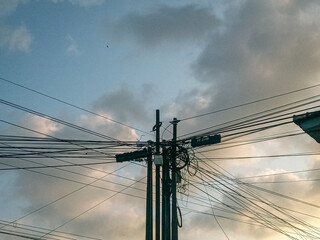 lines in the afternoon sky. aesthetic view of two electricity poles in the afternoon under a thick cloudy sky. dangerously chaotic power lines in the middle of the city. power line cable