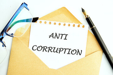 Corruption and another financial concept. ANTI CORRUPTION words on a piece of paper sticking out of a postal envelope