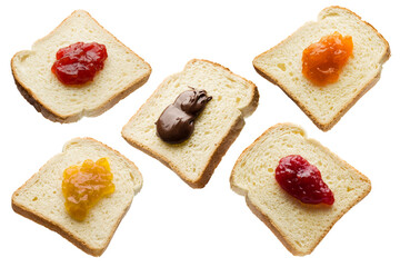 Slices of white bread with variety of jam isolated on white background.