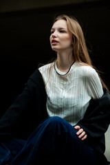 Young woman with long hair black jacket and white trousers street style