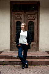 Young woman with long hair black jacket and white trousers street style