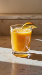 A glass of orange juice with a slice of orange on top