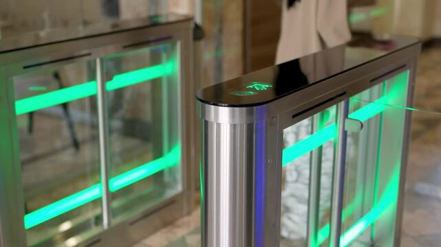 A professional businesswoman uses her personal access card to smoothly enter her workplace through a modern turnstile in a stylish office lobby. Perfect for themes of office security, efficiency
