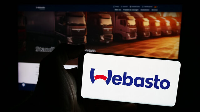 Stuttgart, Germany - 08-05-2024: Person holding smartphone with logo of German automotive company Webasto SE in front of website. Focus on phone display.
