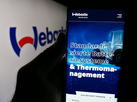 Stuttgart, Germany - 08-05-2024: Person holding smartphone with webpage of German automotive company Webasto SE in front of business logo. Focus on center of phone display.