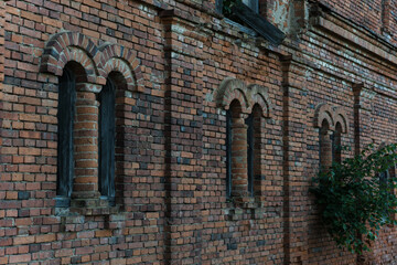 Vertical, narrow windows of a brick stable. 19th century building