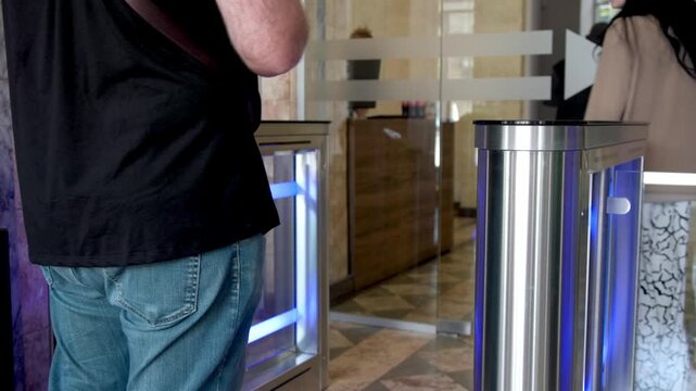 A businesswoman and businessman use their personal access cards to enter a sleek modern office. Ideal for showcasing office security, professional environments, and cutting-edge workplace technology.