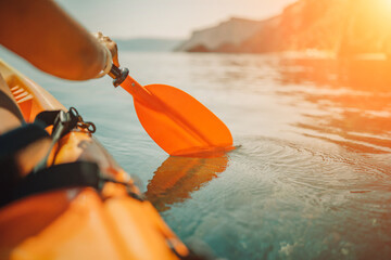 Kayak paddle sea vacation. Person paddles with orange paddle oar on kayak in sea. Leisure active...