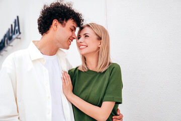 Smiling beautiful woman and her handsome boyfriend. Couple in casual summer clothes. Happy cheerful family. Female and man having fun. They posing in the street in sunny day. Having tender moments