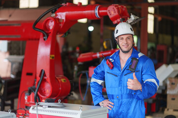portrait young caucasian male welding robot factory engineer in protective workwear standing and doing thumb up in automated manufacturing industry