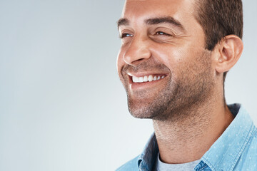 Obraz premium Thinking, mockup space and face of man with smile for brainstorming, ideas and cheerful. Thoughtful, happy and confident model on white background for choice, decision and wondering in studio
