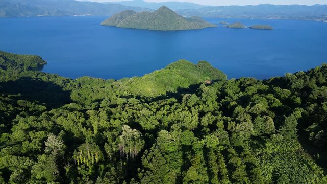 Lake Toya, Hokkaido, Japan: Aerial drone footage of the lake Toya with the Nakajima island in Hokkaido in summer. Shot with a tilt up motion 