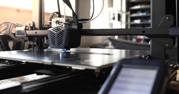 Close-up of a 3D printer head working in the rays of the setting sun. 3D printing technology in dynamic lighting, perfect for illustrating modern manufacturing.