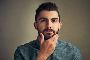 Beard, man and thinking in studio for hair care, date preparation and daily routine. Male person, grooming or touch face on dark background with confidence, natural aesthetic and facial treatment