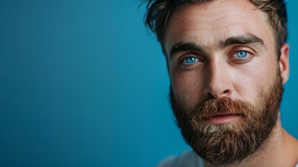 Obraz premium A man with a beard and blue eyes is looking at the camera