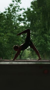 Girl doing yoga in the rain with trees in the background