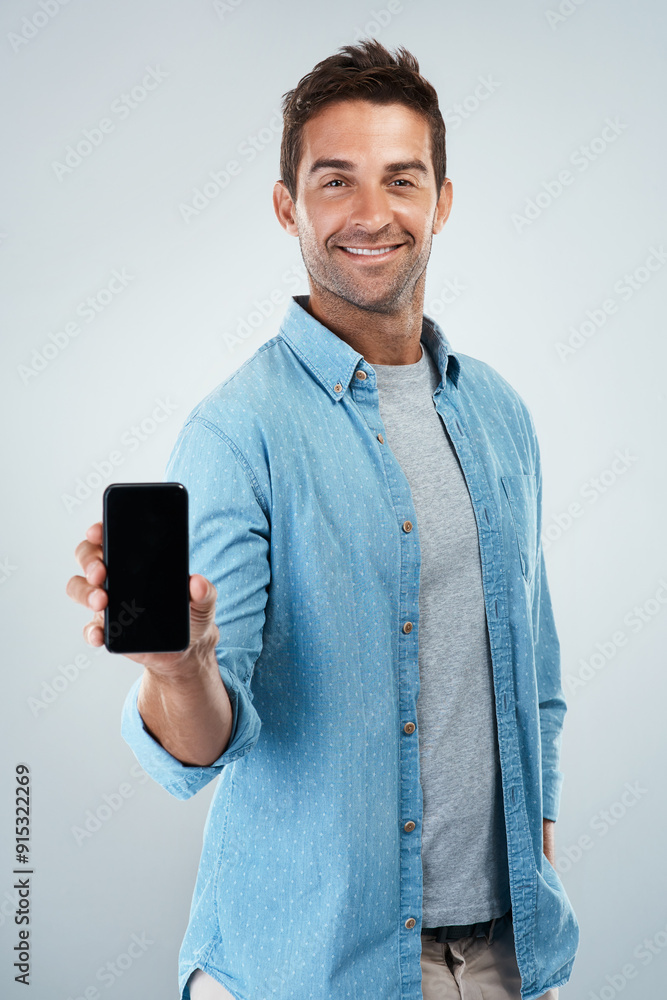 Poster Advertising, phone screen and portrait of casual man in studio on white background for communication. App, smile and social media marketing with happy person showing mobile display for networking
