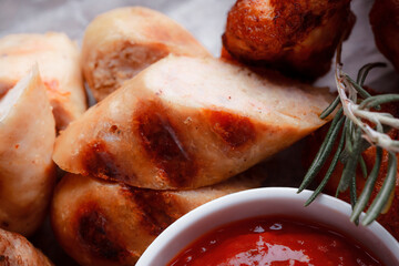 Original serving of meat dishes. Crispy fried chicken wings and thighs. Breaded cheese balls and grilled sausages with rosemary and ketchup. Food for outdoor catering.