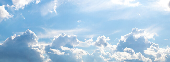 White curly clouds illuminated by the bright sun