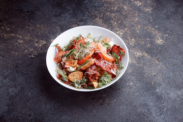 Salad panzanella of tomatoes and paper with fresh greens. Fresh vegetable mix at dark table. Top view, Copy space.