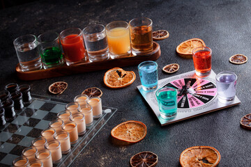 Short alcoholic drinks for a bar cocktail card. Party concept for girls. Multicolored cocktail tubes. Row of glasses with fruit mojito cocktails. Alcohol games for night clubs.