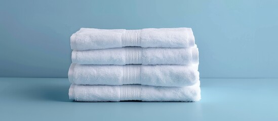 Cropped image of an individual arranging clean white towels on a blue surface. with copy space image. Place for adding text or design
