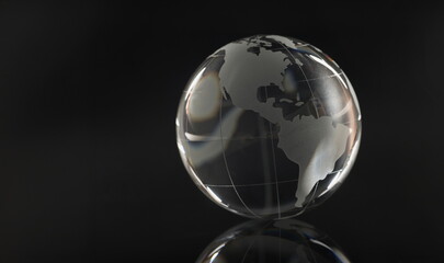 Glass transparent globe on a black background, reflection, close-up. The concept of a world in darkness, cleansing