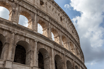 Fototapeta premium Left side of frame Roman Colosseum with clouds in sky on warm day