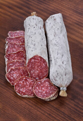 traditional Spanish salami fuet sausage or dry sausage cut in slices in a kitchen table.