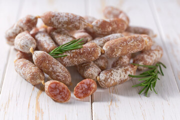 Spicy pork fermented dry cured sausages on a light background. Cocktail Salami mini.