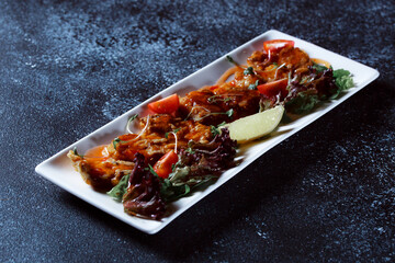Vegetable stew. Boiled vegetables served in a restaurant. White plate on a dark blue background.
