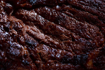 A large piece of spicy grilled meat. Bone-fried meat with spices. Restaurant serving dishes with sauce and micro-herbs.