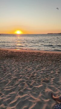 A stunning sunset graces the horizon, casting a warm glow over the ocean waves gently lapping the sandy shore, evoking peace, tranquility, and the beauty of nature's end-of-day spectacle.