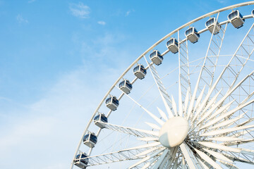 A large ferris wheel in an amusement park under a partly cloudy sky, offering panoramic views and...